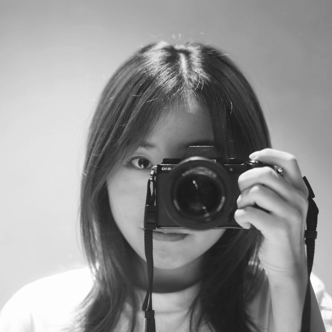 Black-and-white portrait of Lu Kang holding a camera